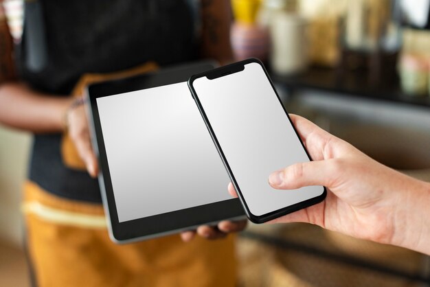 Blank tablet and smartphone screen in a small business shop