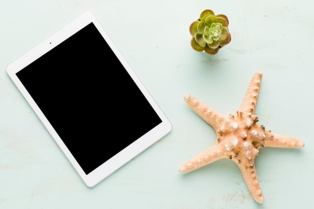 Blank tablet with starfish on light surface