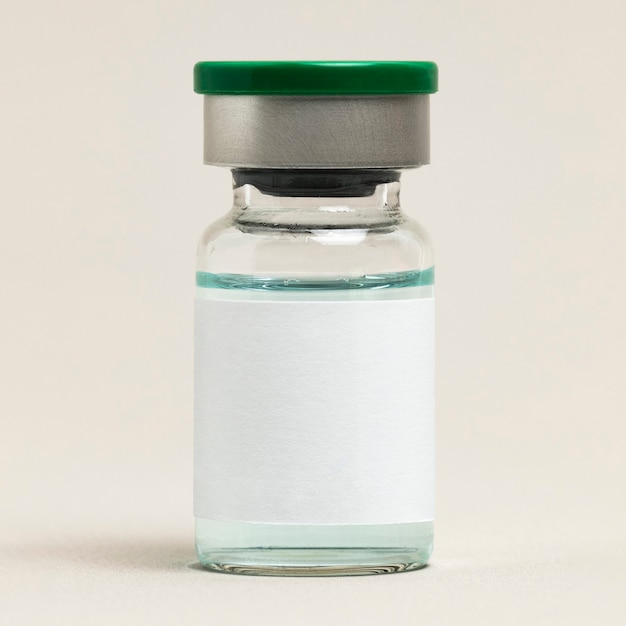 Пустая этикетка вакцины на стеклянной бутылке для инъекций с зеленой жидкостью