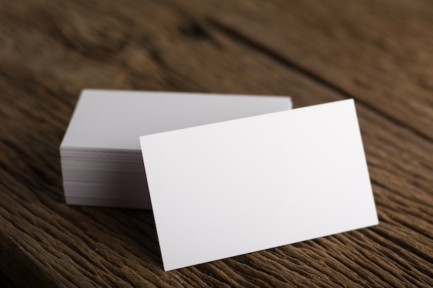 Blank white business card presentation of corporate identity on wood background