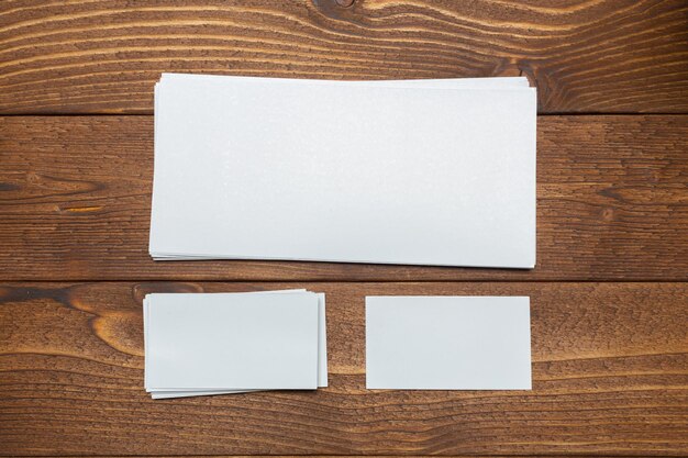 Blank white business cards on wooden background.