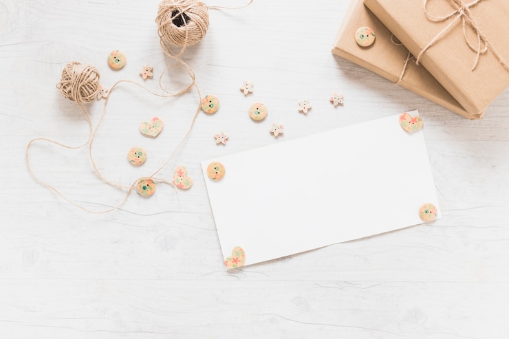 Free Photo blank white card decorated with wooden button with spool and boxes