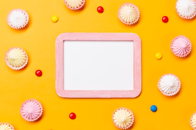 Free photo blank white frame surrounded with colorful gems and aalaw on yellow backdrop