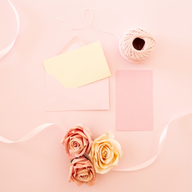 Biglietto di auguri bianco vuoto con bouquet di fiori di rosa rosa e busta con boccioli di fiori
