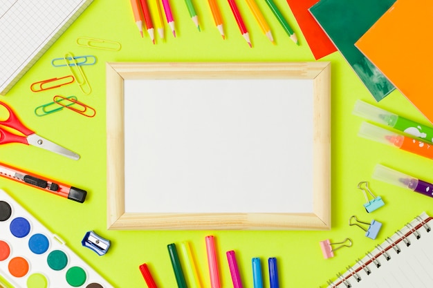 Blank wooden frame and school supplies