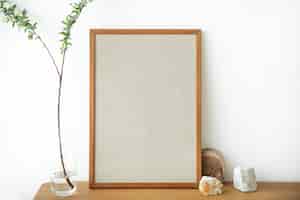 Бесплатное фото Пустая деревянная рамка на фоне белой стены