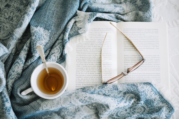 Blanket near tea and opened book