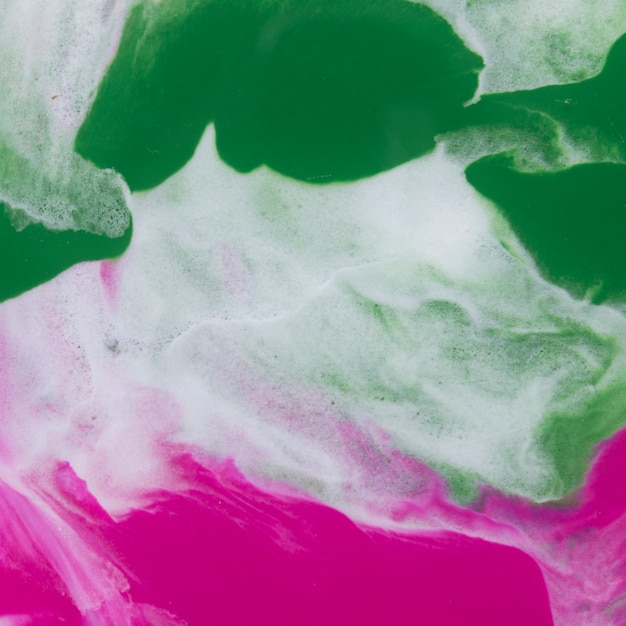 白い紙に織り目加工の抽象的な緑とピンクの水彩画のブレンド