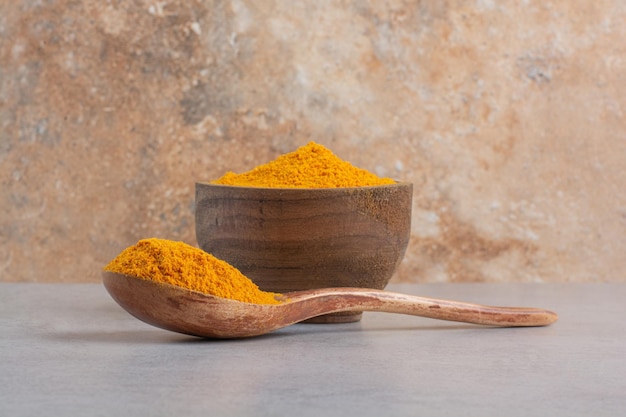 Blended curcumin powder in a wooden spoon. 