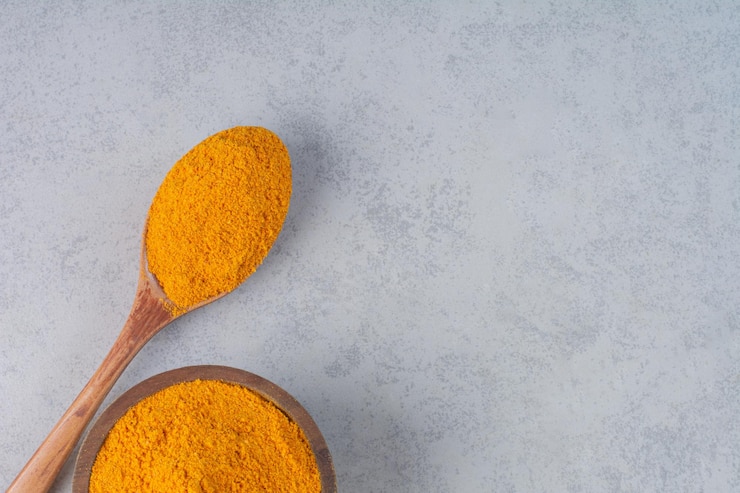 Free Photo blended curcumin powder in a wooden spoon. 