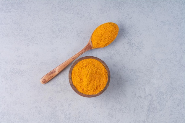 Blended curcumin powder in a wooden spoon. 