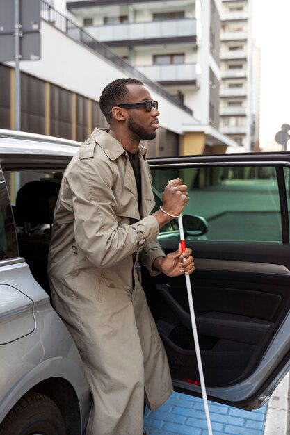 Blind man getting out of car full shot