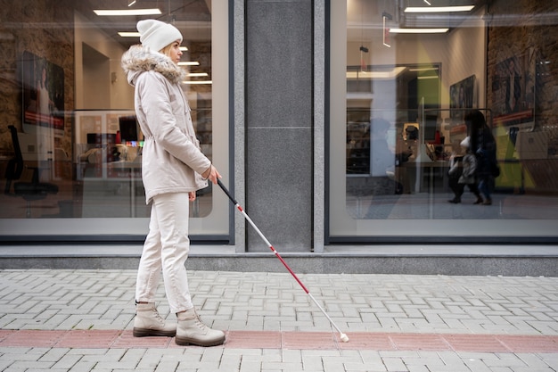 Free photo blind person walking through the city with blind stick