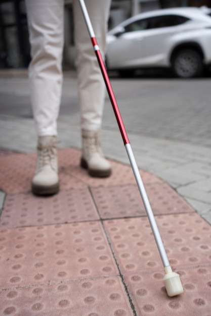 Free photo blind person walking through the city with blind stick