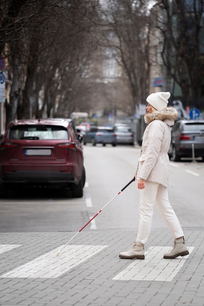 Free photo blind person walking through the city with blind stick