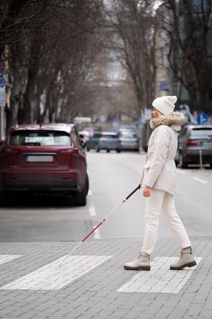 盲目の棒で街を歩いている盲人