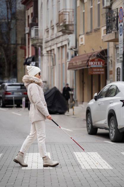 Blind person walking through the city with blind stick