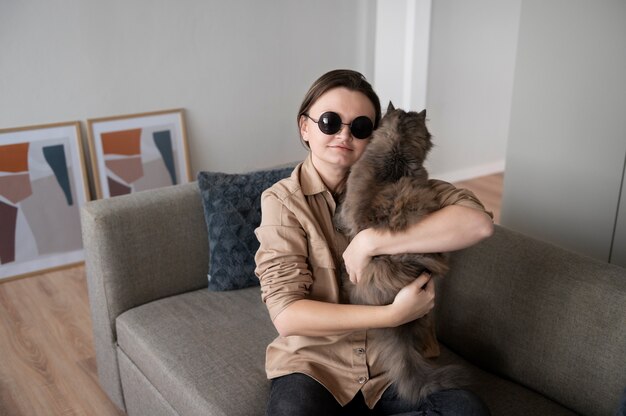 그녀의 고양이를 안고 있는 시각 장애인 여성
