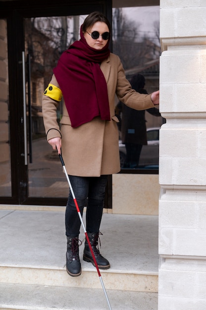 Free photo blind woman walking using her walking stick