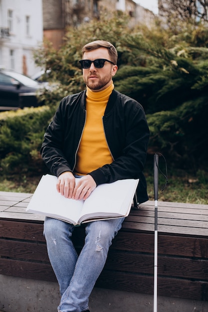 Blinded man reading by touching braille book