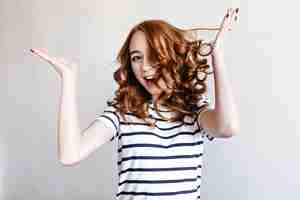 Free photo blissful ginger girl with pale skin fooling around. indoor portrait of caucasian red-haired woman having fun during photoshoot.