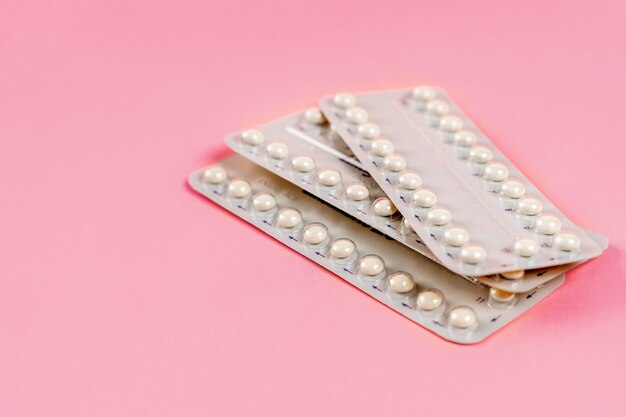 A blister of birth control pills on a pink background the concept of the method of contraception