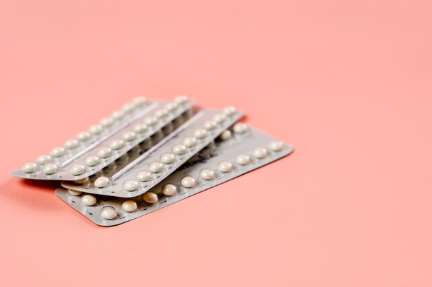 A blister of birth control pills on a pink background the concept of the method of contraception