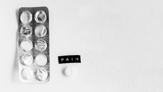 Blister pack and pill near the pain text
