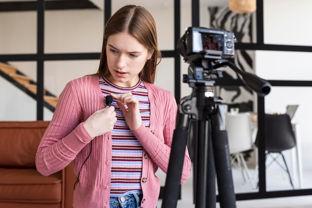 Free photo blogger adjusting the mic in front of the camera