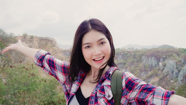 Blogger Asian backpacker woman record vlog video on top of mountain