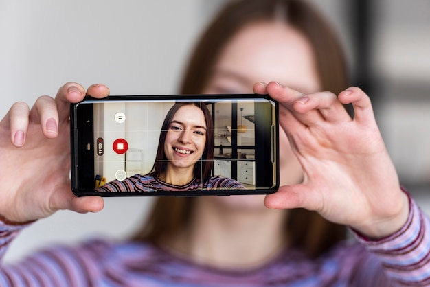 Blogger holding phone and recording herself