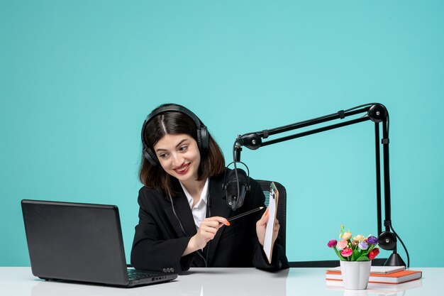 Blogger journalist cute pretty girl in black blazer recording speech on camera pointing on notes