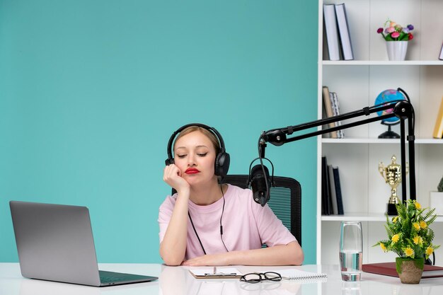 Blogger journalist cute young blonde girl recording video on computer bored