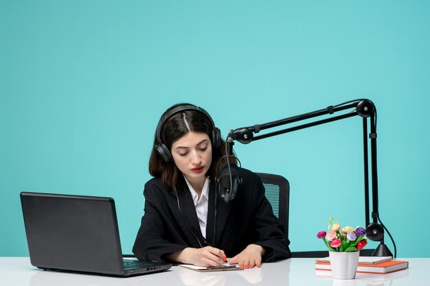 Free photo blogger journalist lovely young girl in black blazer recording speech on camera writing notes