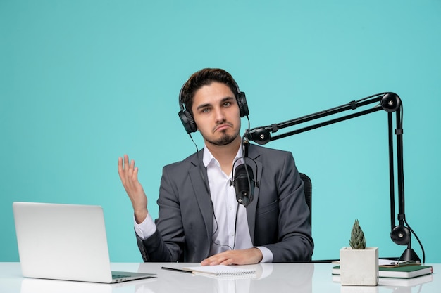 Blogger journalist serious cute handsome guy recording video in grey suit waving hands