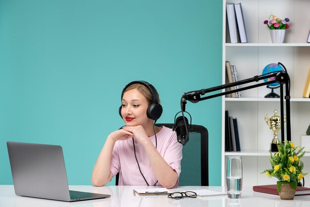 Blogger journalist young cute blonde girl recording video on computer in office lovely sitting