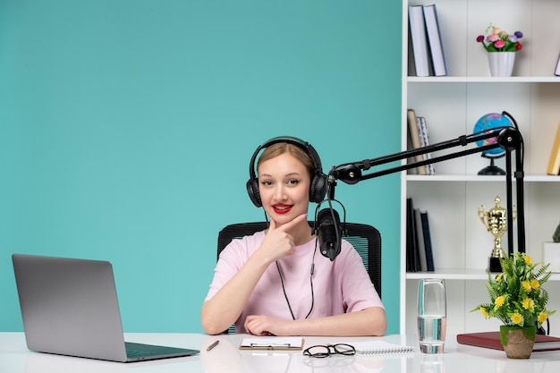 Blogger journalist young cute blonde girl recording video on computer in office smiling