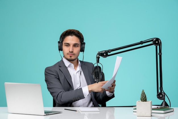 Blogger journalist young cute handsome guy in grey suit recording video holding script