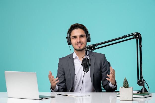 Blogger journalist young cute handsome guy in grey suit recording video waving hands