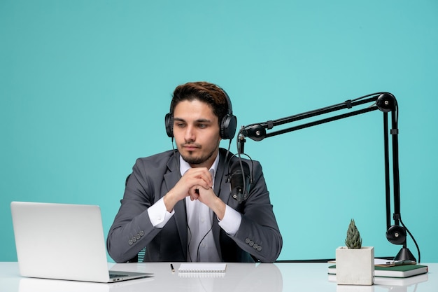 Blogger journalist young cute handsome guy in grey suit recording video