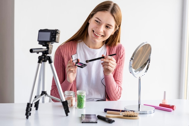 Foto gratuita blogger che presenta accessori per il trucco