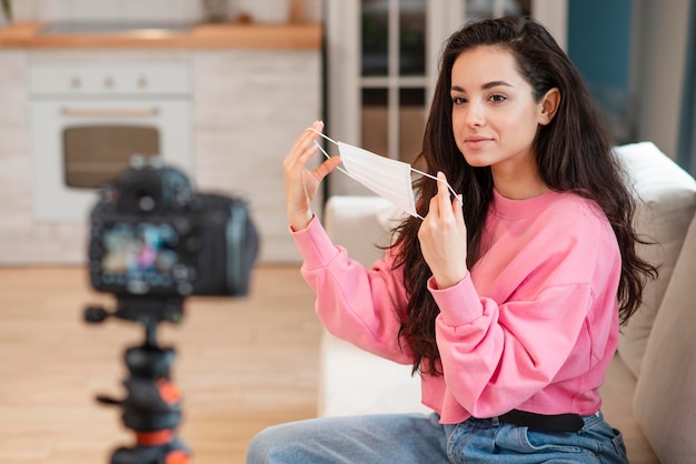 Blogger putting surgical mask on in front of camera