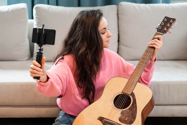Free photo blogger recording with smartphone her guitar