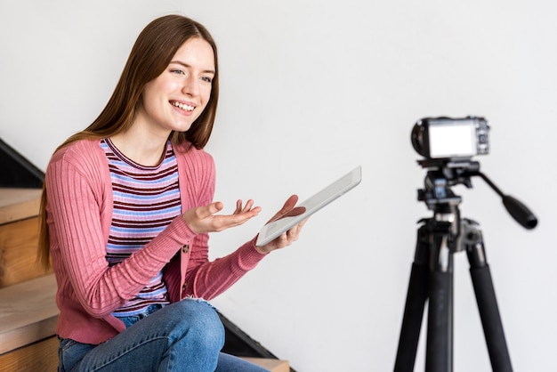 Blogger using tablet and talking to camera