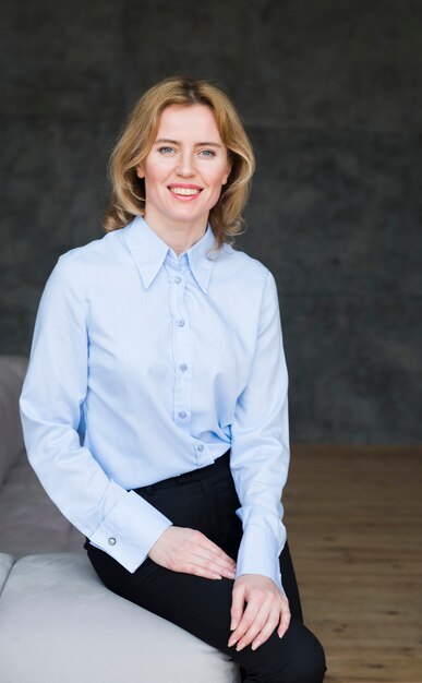 Blond business woman sitting on couch 