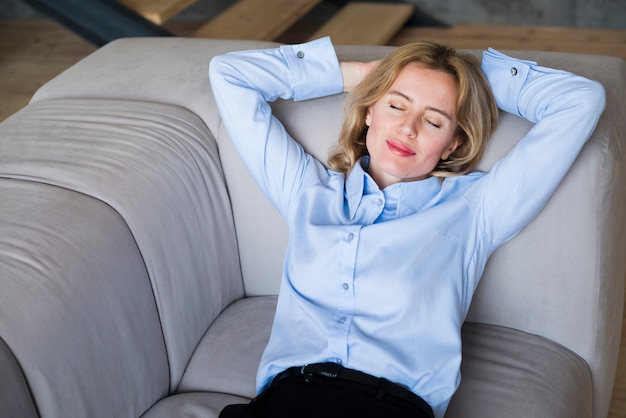 Блондинка деловая женщина спит на диване