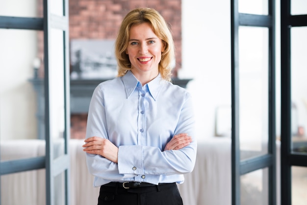 Blond business woman standing with crossed arms 