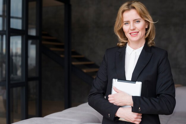 Blond business woman in suit with tablet