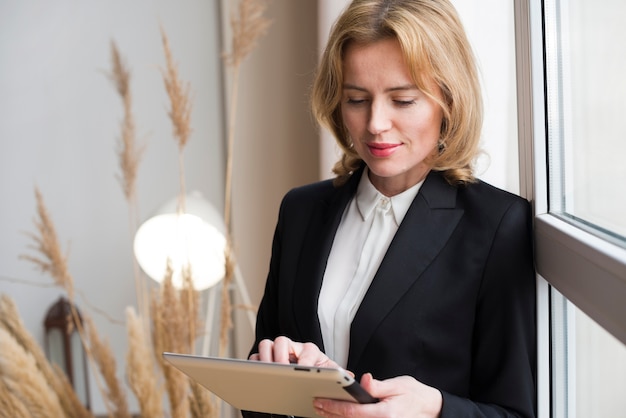 Free photo blond business woman using tablet