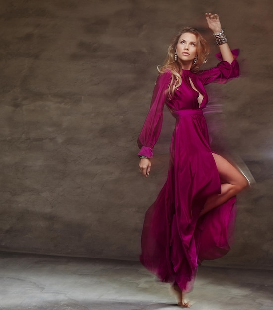 Blond female dancing  in long red dress